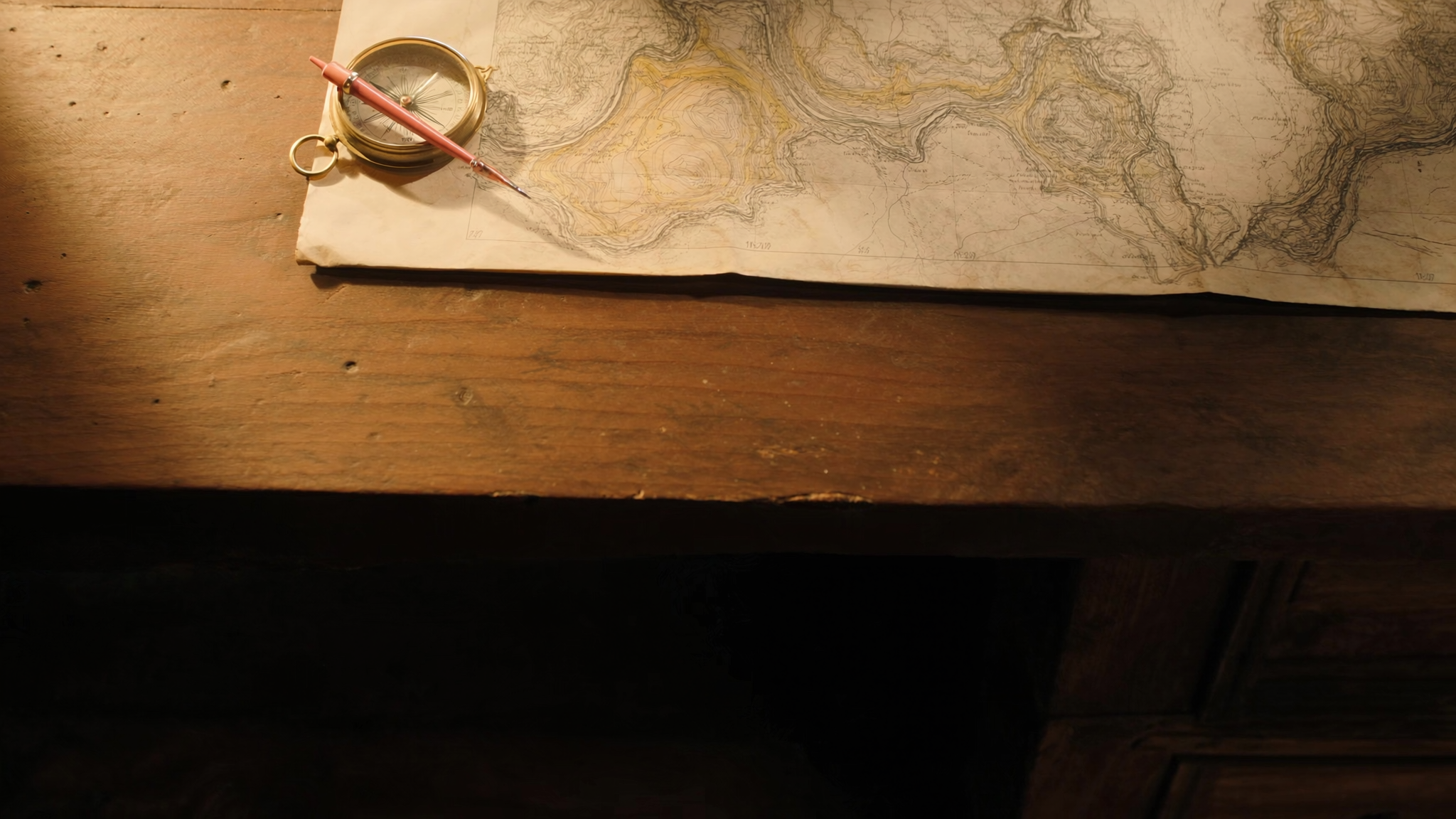 Editorial still: a brass compass and pencil resting on a topographic map